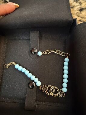 CHANEL Gold-Tone Bracelet with Light Blue Beads and Logo Charm